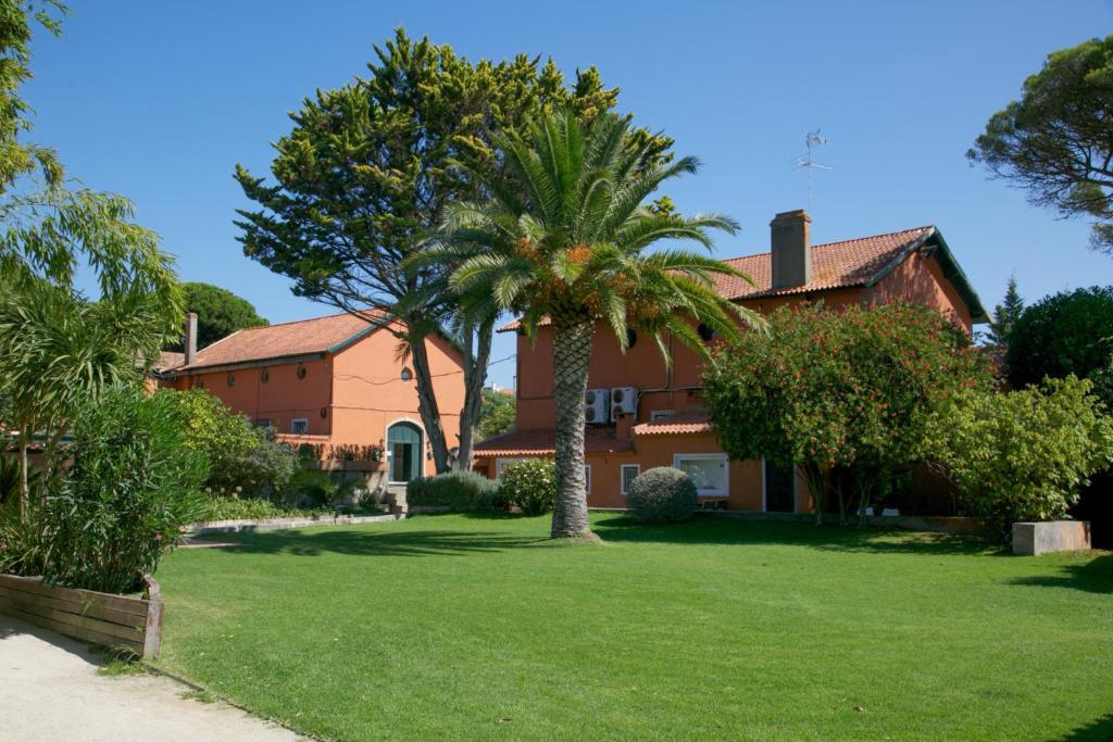 a house with palm trees in a yard at Quinta da Bicuda in Cascais