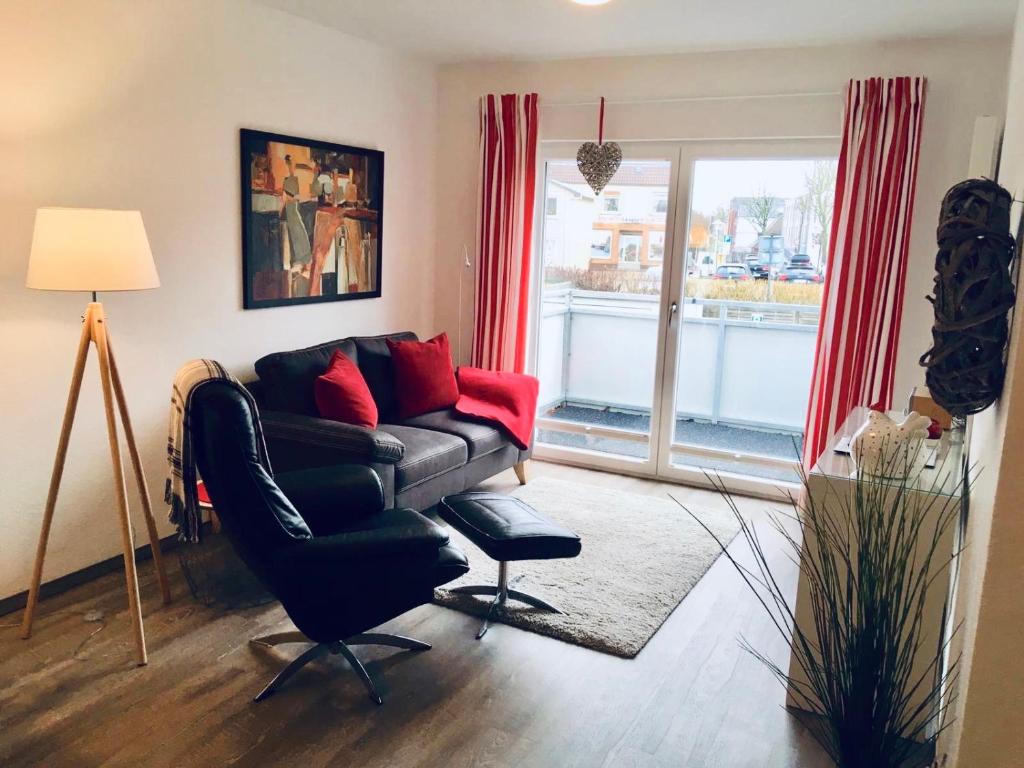 a living room with a couch and a chair and a window at Apartment Alleestraße in Büsum