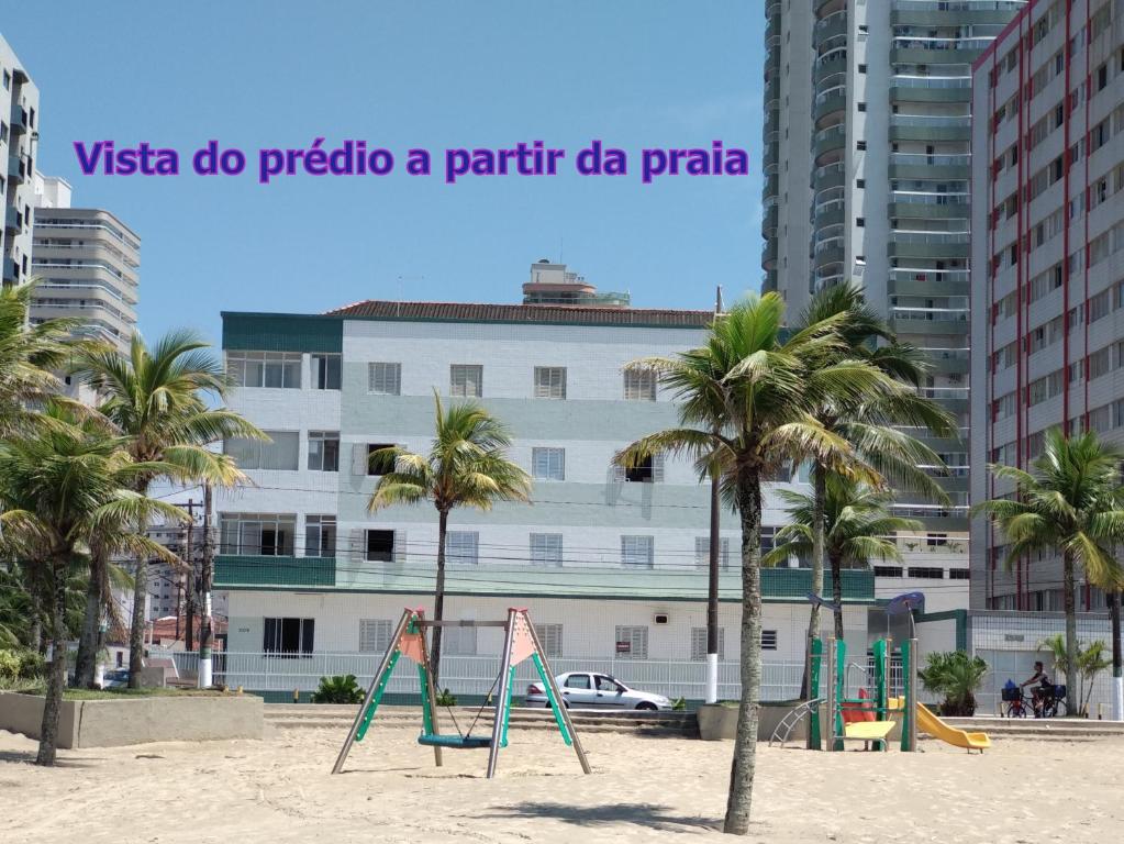 a playground on a beach with palm trees at Edificio Edmeia in Praia Grande