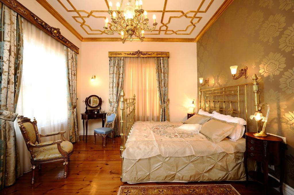 1 dormitorio con cama y lámpara de araña en Erten Konak, en Estambul