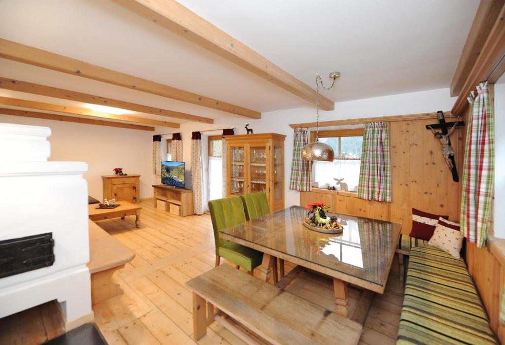フィーホーフェンにあるChalet Glemmtal - Haus Dorfblickのテーブルと緑の椅子のあるダイニングルーム