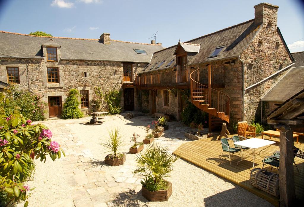 a large stone house with a patio and a staircase at Relais Saint Aubin in Erquy
