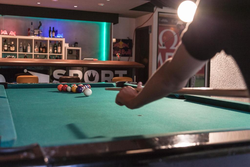 una persona está jugando al billar en una mesa de billar en Sport Palace, en Crans-Montana
