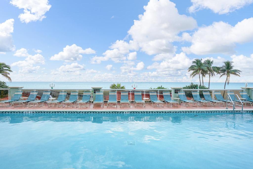 una piscina con sedie e l'oceano sullo sfondo di Hollywood Beach Tower by Capital Vacations a Hollywood