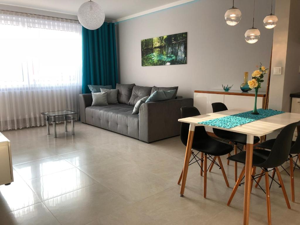 uma sala de estar com um sofá e uma mesa em Apartamenty MAJA Nowy Targ em Nowy Targ