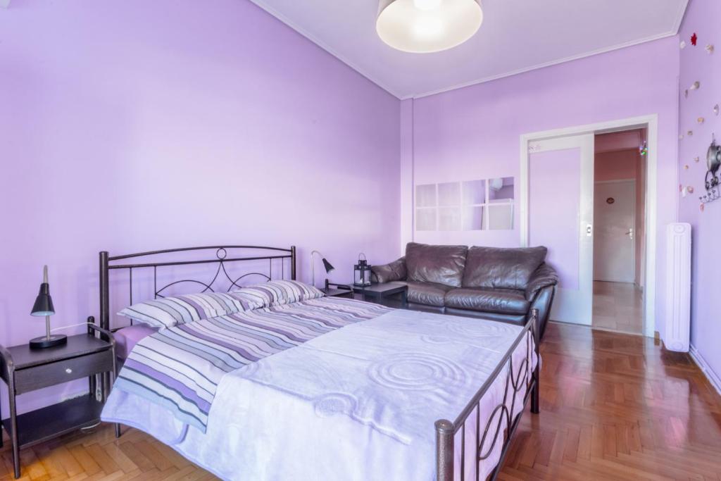 a bedroom with a large bed and a couch at Petaluda House 1 in Athens