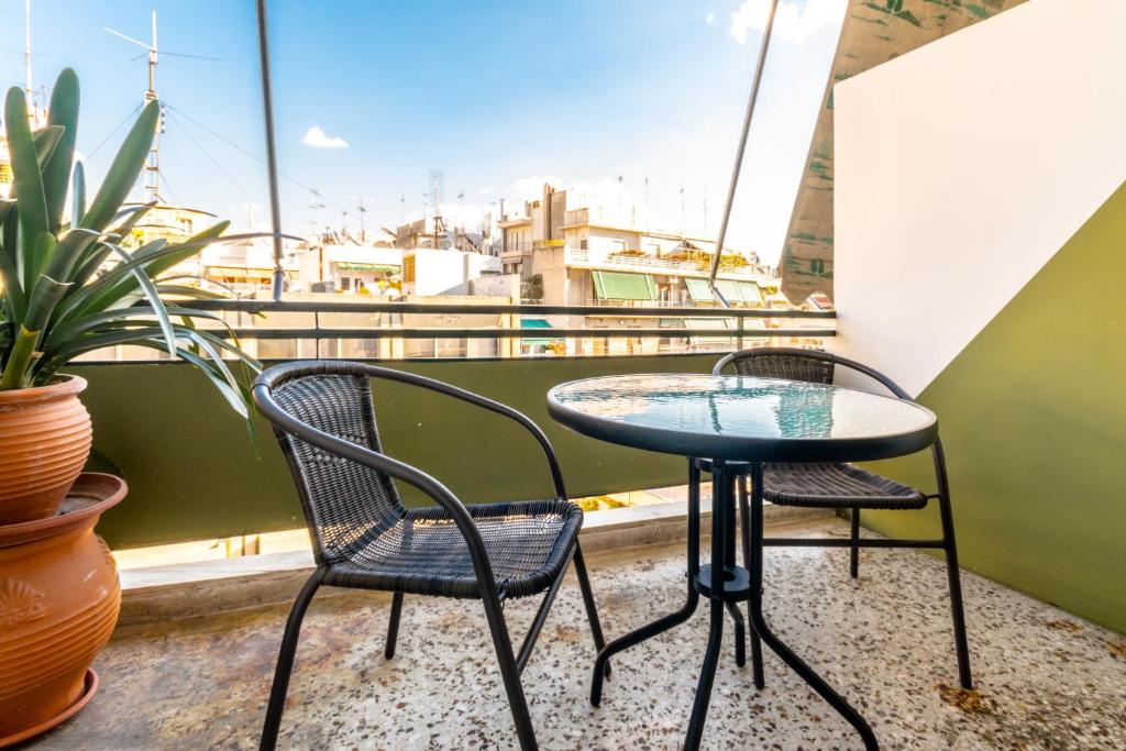 two chairs and a table on a balcony at Petaluda House 1 in Athens