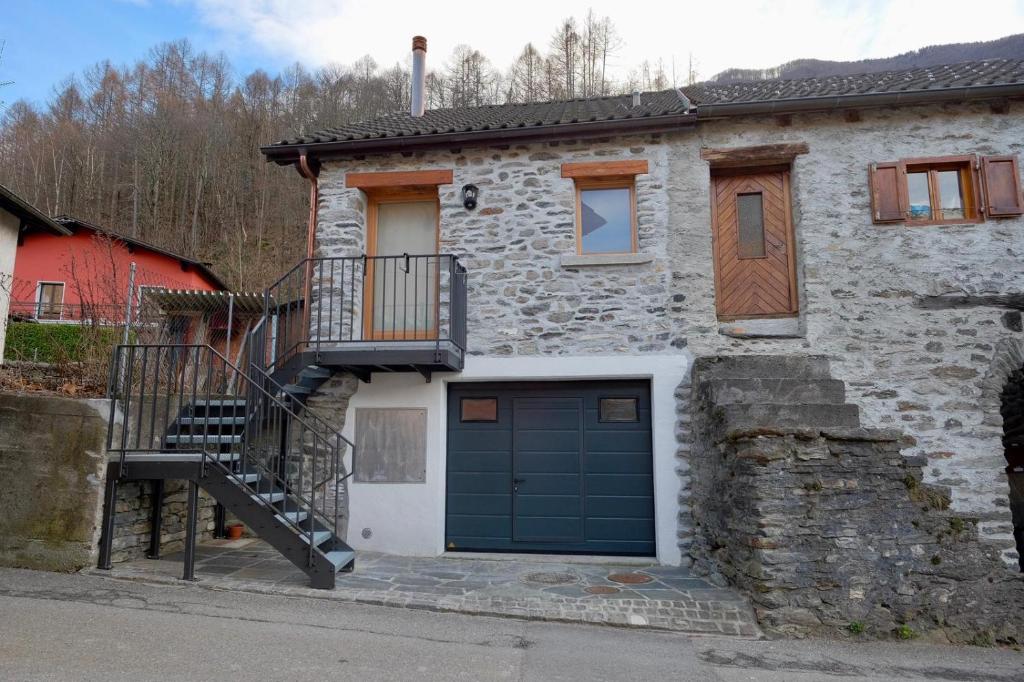 a stone house with a garage and a staircase at El Stanzion in Roveredo