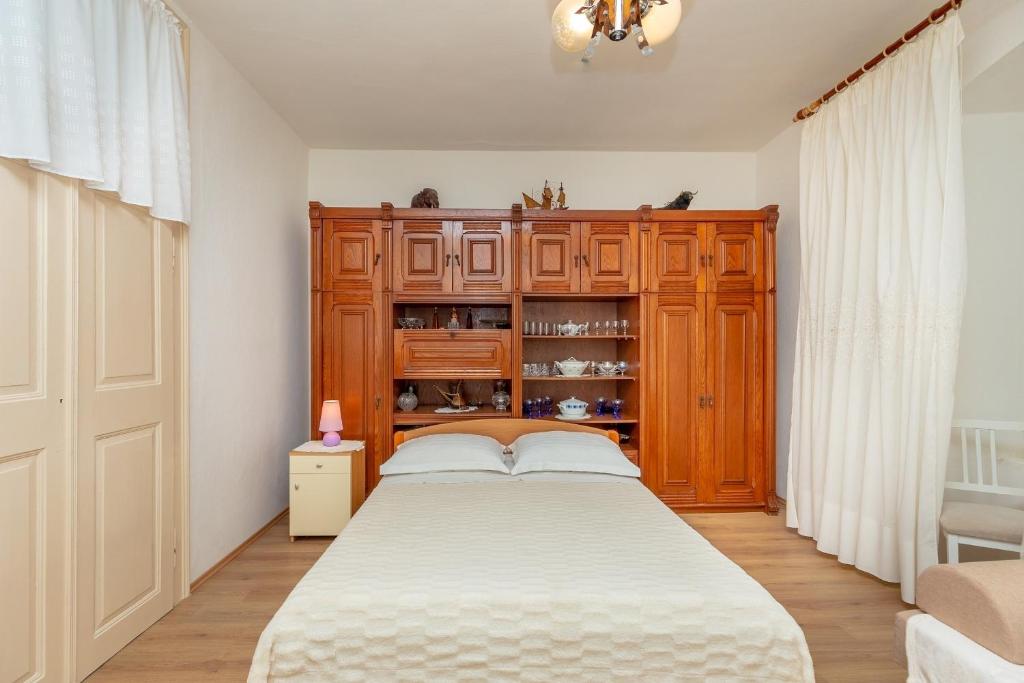 1 dormitorio con 1 cama y armario de madera en Apartment Matić, en Dubrovnik