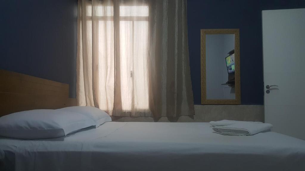 a bedroom with a bed and a mirror and a window at Casa Capitólio I in Capitólio