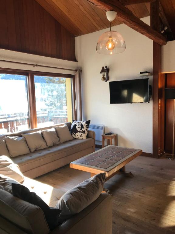 a living room with a couch and a table at Chalet 12 personnes Montgenèvre in Montgenèvre