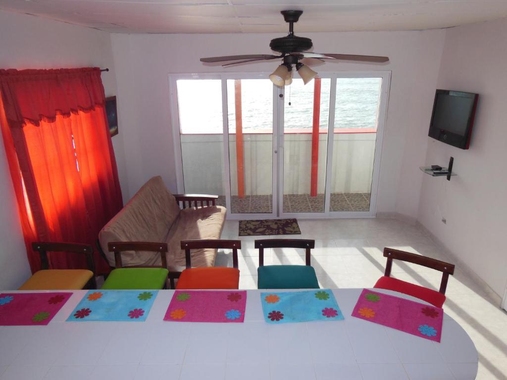 - un salon avec une table, des chaises et un ventilateur de plafond dans l'établissement Apartamentos Rocky Cay Bay, à San Andrés
