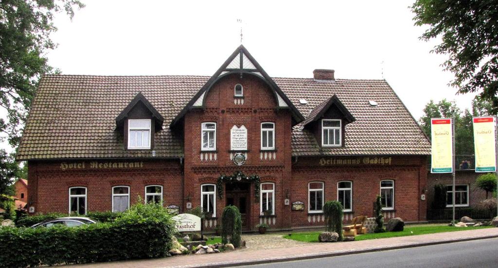 un gran edificio de ladrillo rojo con techo de gambrel en Heitmann`s Gasthof en Kirchlinteln