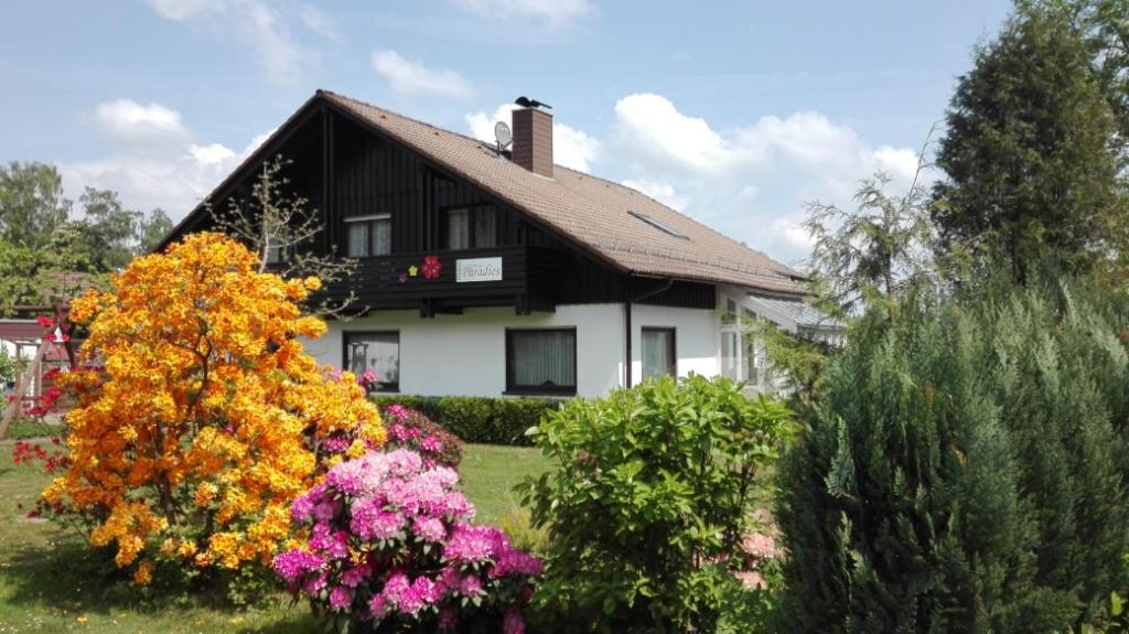 ein Haus mit Blumen davor in der Unterkunft Hotel Grünes Paradies- Garni in Hochwaldhausen