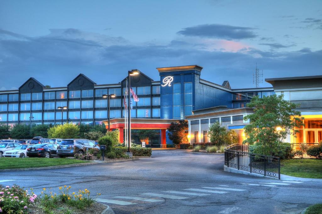 um grande edifício com carros estacionados num parque de estacionamento em The Ramsey Hotel and Convention Center em Pigeon Forge