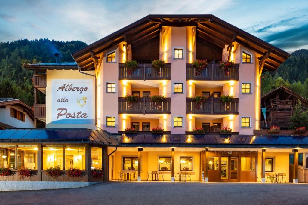 マドンナ・ディ・カンピリオにあるAlbergo alla Postaのアレグヘンとプルを読む看板のあるホテル