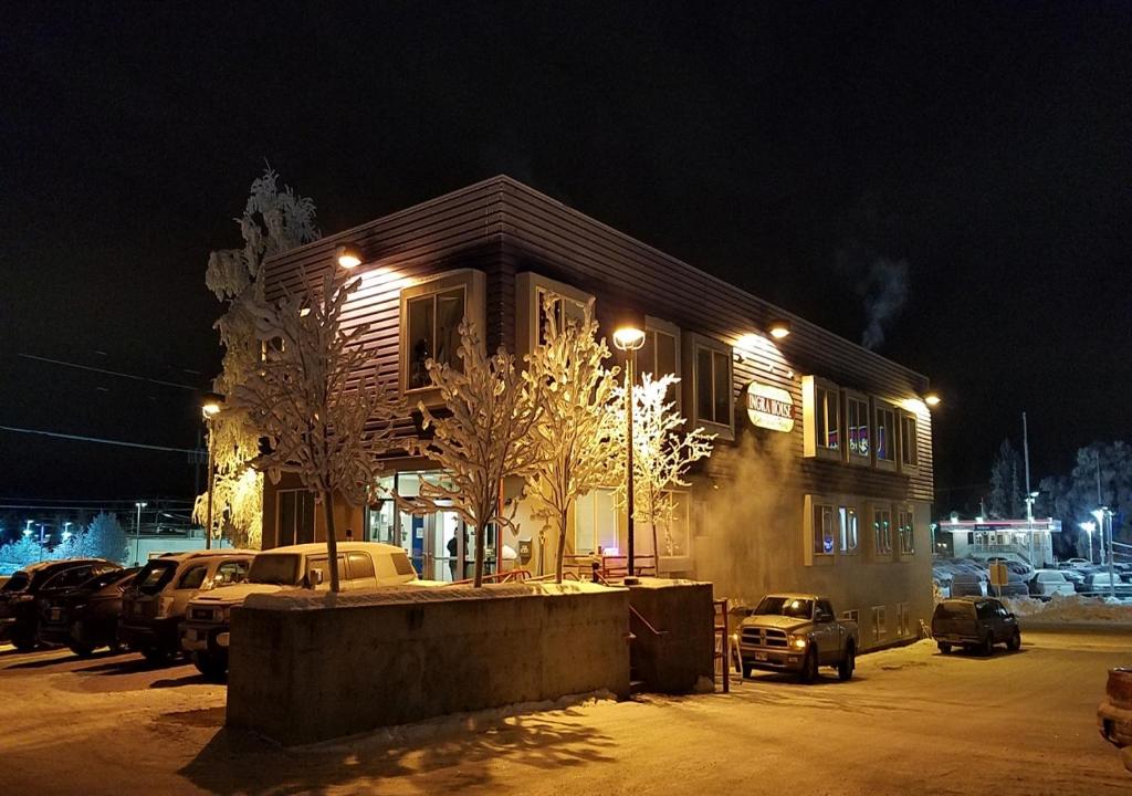 a building with cars parked in a parking lot at night at Ingra House Hotel in Anchorage