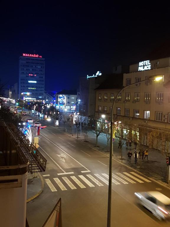 a city street at night with a car on the street at SARA Apartment in Banja Luka