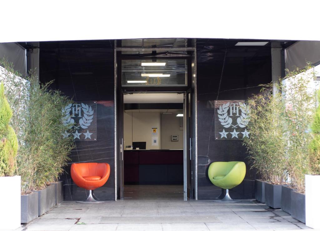 an entrance to an office with two green and orange chairs at Tiby Hotel in Modena