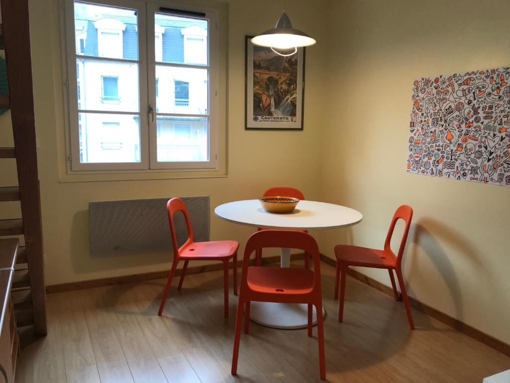 einen Tisch und 4 Stühle in einem Zimmer mit Fenster in der Unterkunft Cosy T2 mezzanine pour 4 personnes in Cauterets