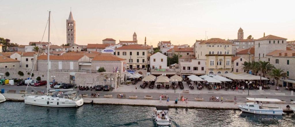 eine Stadt mit einem Yachthafen mit Booten im Wasser in der Unterkunft Apartments Residence Astoria in Rab