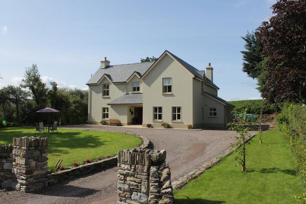 a large white house with a stone wall at The Twelve Oaks in Kenmare