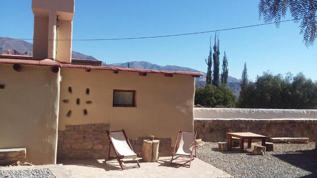 La Cabañita de Tilcara في تيلكارا: كرسيين وطاولة أمام المنزل