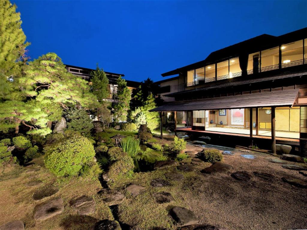 a view of a building with trees and bushes at Yoshitagawa Bekkan in Higashine