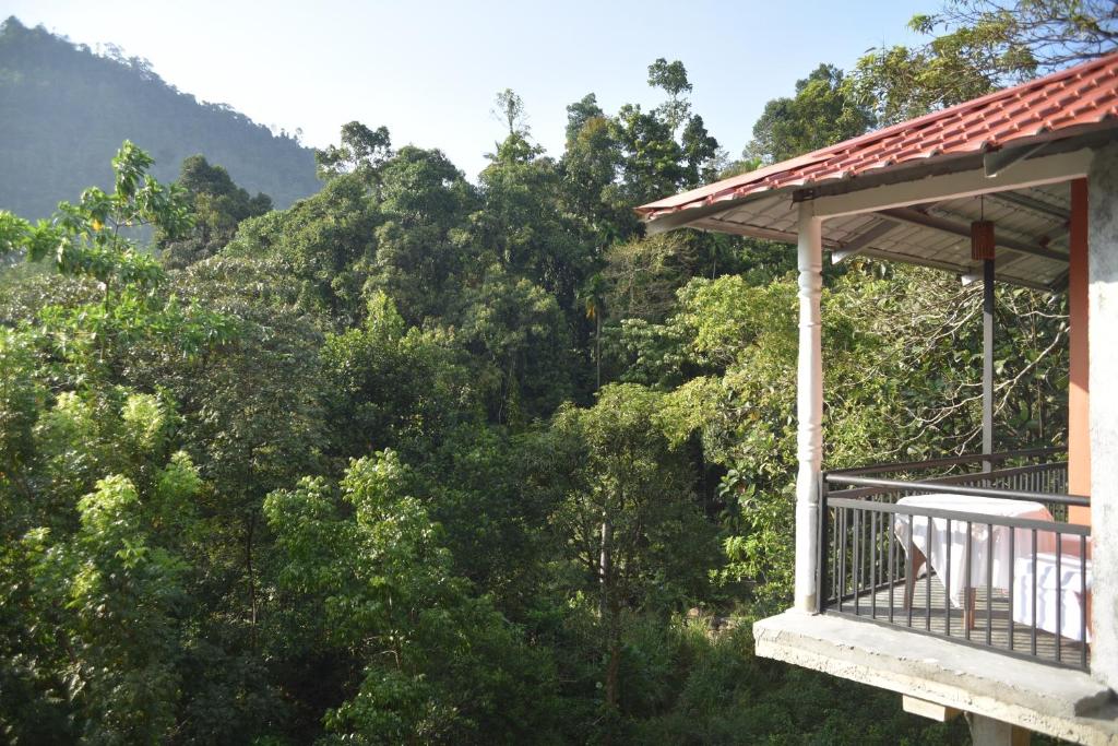 einen Balkon eines Hauses mit Blick auf die Bäume in der Unterkunft White Villa Kitulgala in Kitulgala