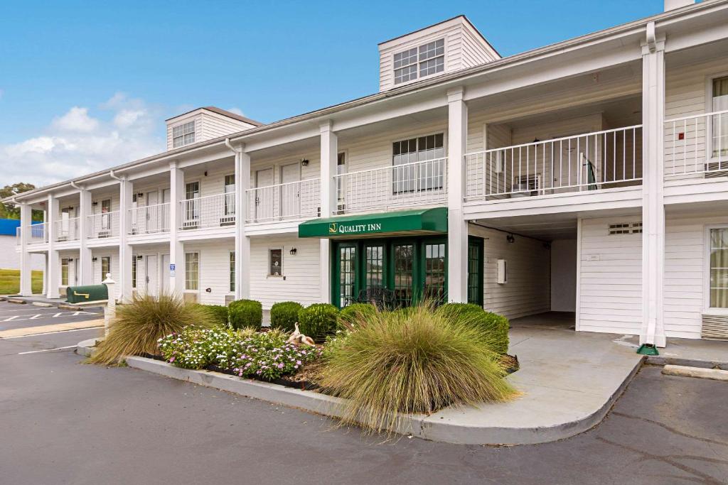 un gran edificio blanco con plantas en un estacionamiento en Quality Inn, en Thomaston