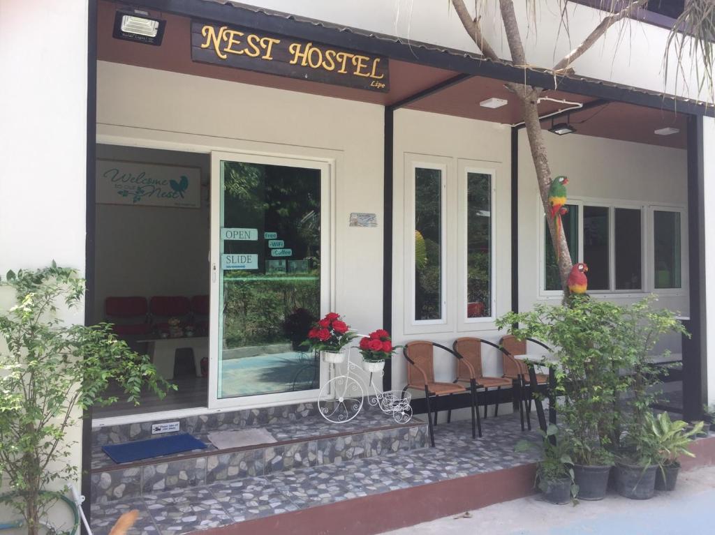 pensjonat ze stołem i krzesłami na zewnątrz w obiekcie Nest hostel lipe w mieście Ko Lipe