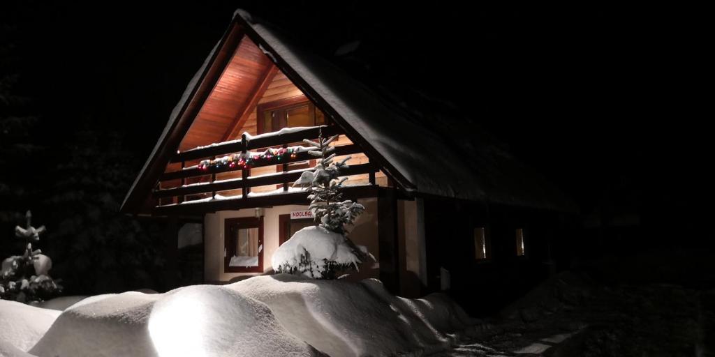 une maison avec de la neige sur son côté dans l'établissement Chata pod pilskom, à Sihelné
