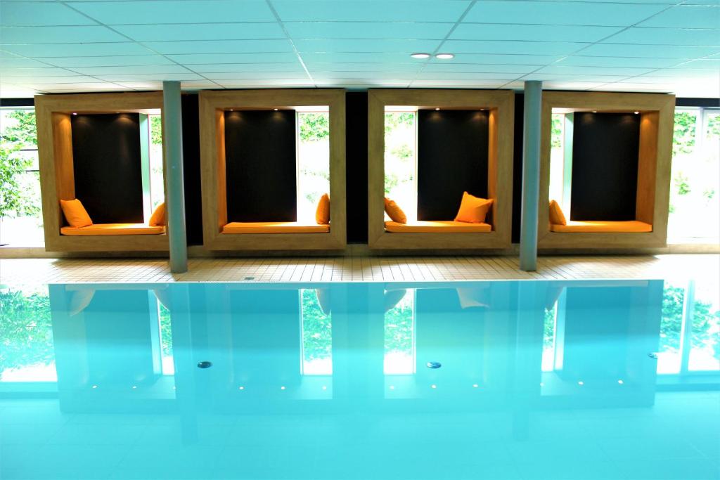 シュルッフゼーにあるAppartementhaus Regina am Schluchseeのオレンジ色の椅子と水の反射が備わる客室です。