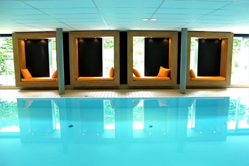 une chambre avec des chaises orange et une réflexion dans l'eau dans l'établissement Appartementhaus Regina am Schluchsee, à Schluchsee