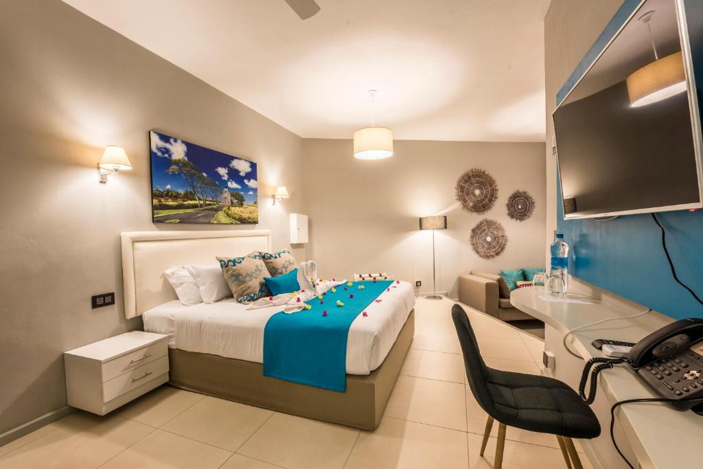1 dormitorio con 1 cama grande con manta azul en Azur Paradise, en Grand Baie