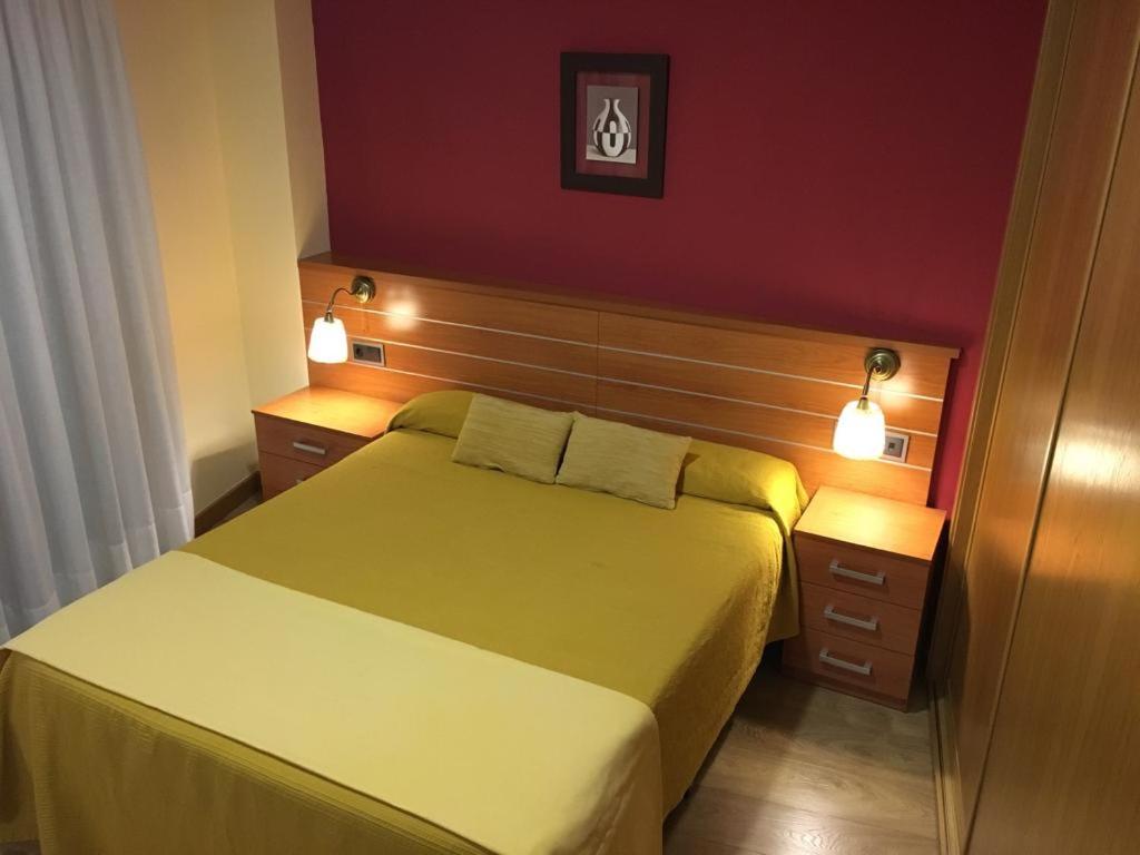 1 dormitorio con 1 cama y 2 mesitas de noche con luces en Hostal Doña Juana, en Ávila