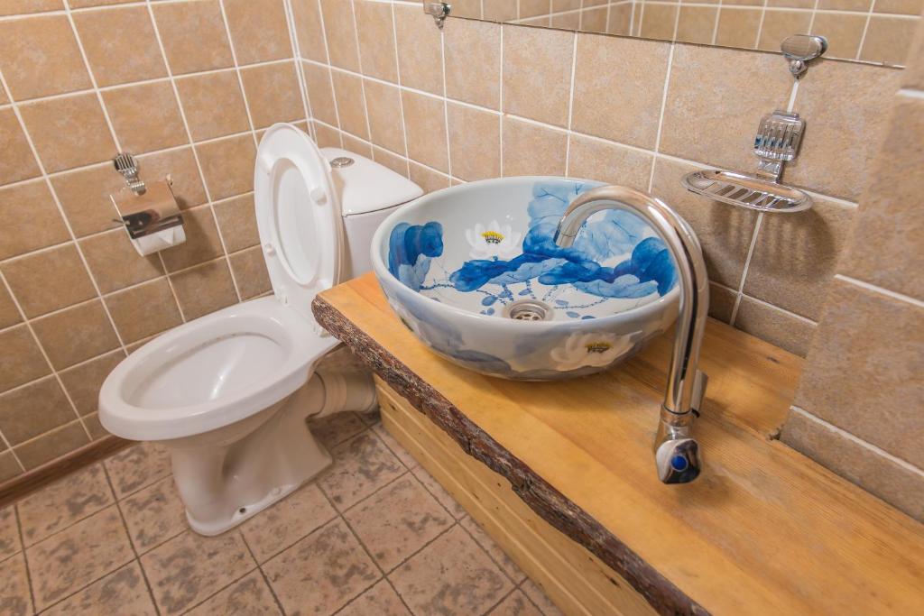 a bathroom with a toilet and a sink at Boutigue Hotel Nebesa in Chimgan