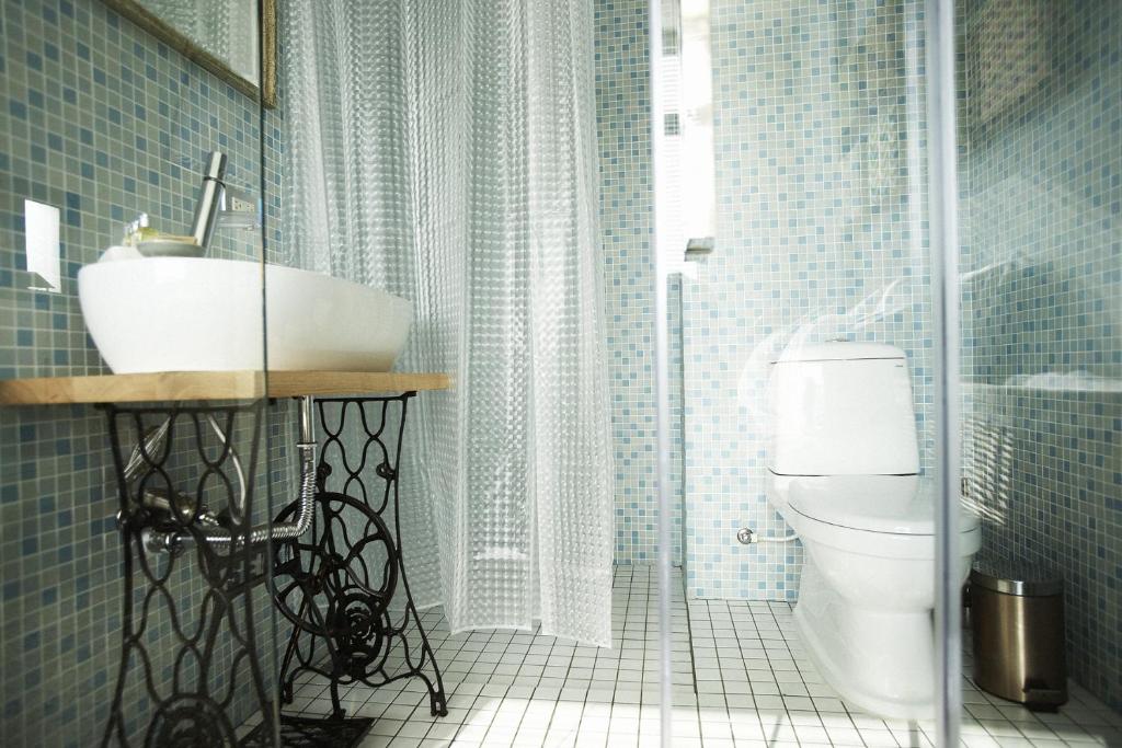a bathroom with a sink and a toilet at Hour Roots in Tainan