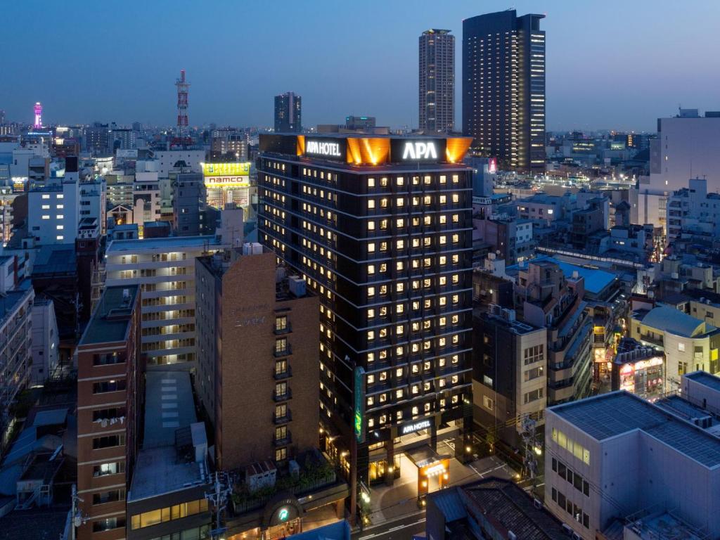 a tall building in a city at night at APA Hotel Namba-Eki Higashi in Osaka