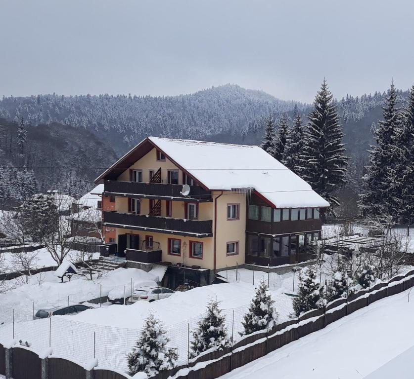 ein großes Gebäude mit Schnee auf dem Dach in der Unterkunft Casa Ticino Predeal in Predeal