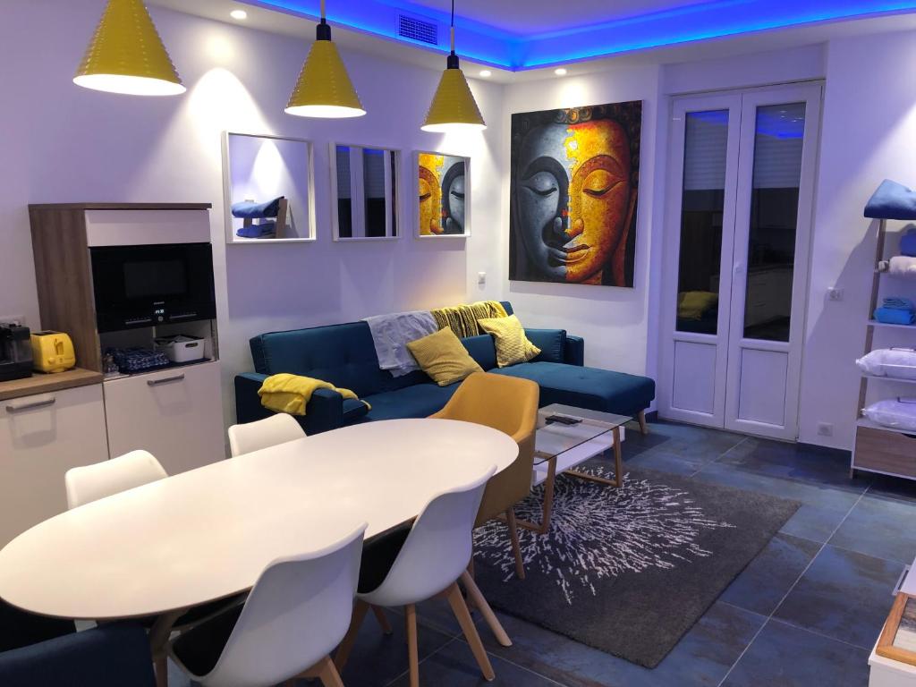 un salon avec une table et un canapé bleu dans l'établissement California, à Nice