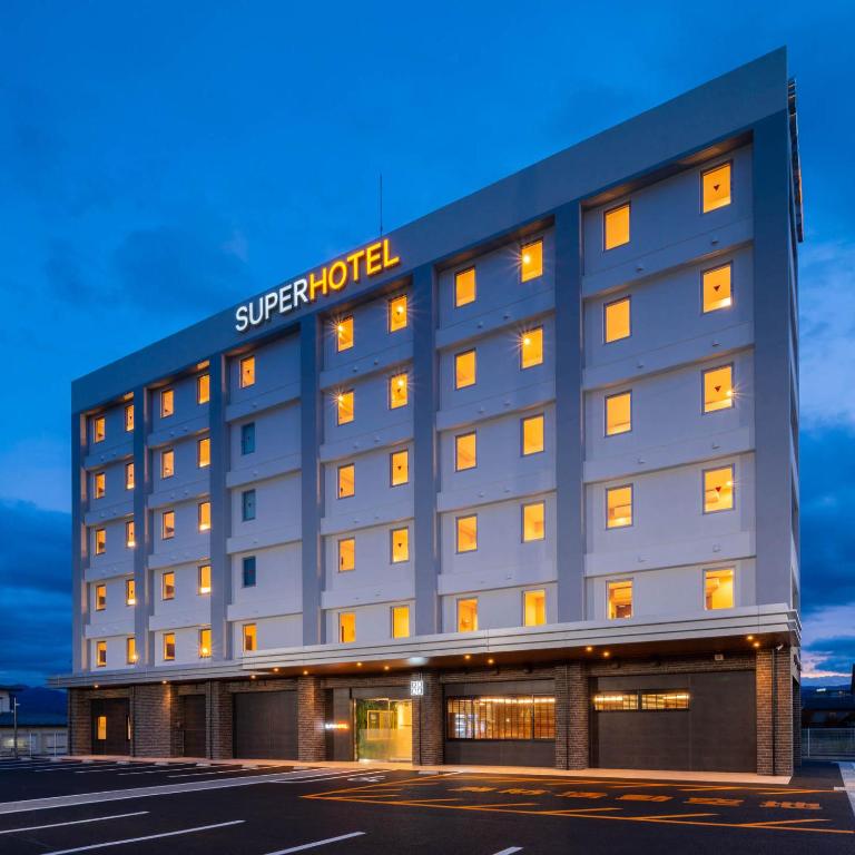 飯田市にあるスーパーホテル長野・飯田インターの建物の横に看板のあるホテル