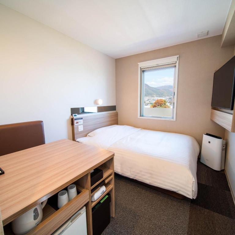 Postel nebo postele na pokoji v ubytování Super Hotel Nagano Iida Inter