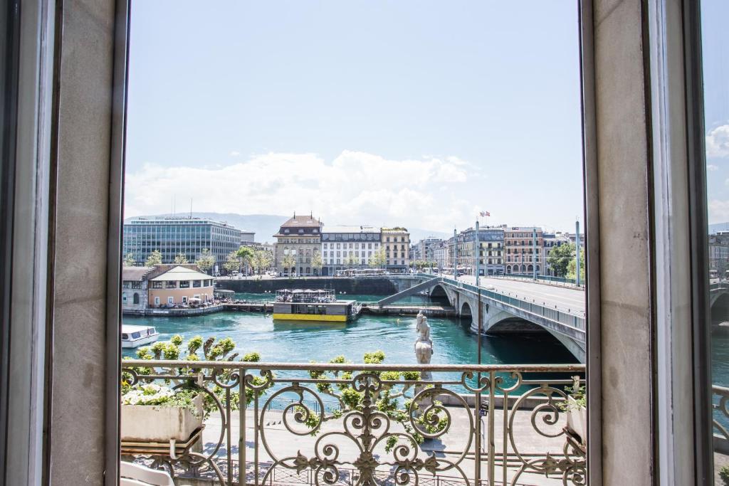 uma varanda com vista para o rio em Hotel des Tourelles em Genebra