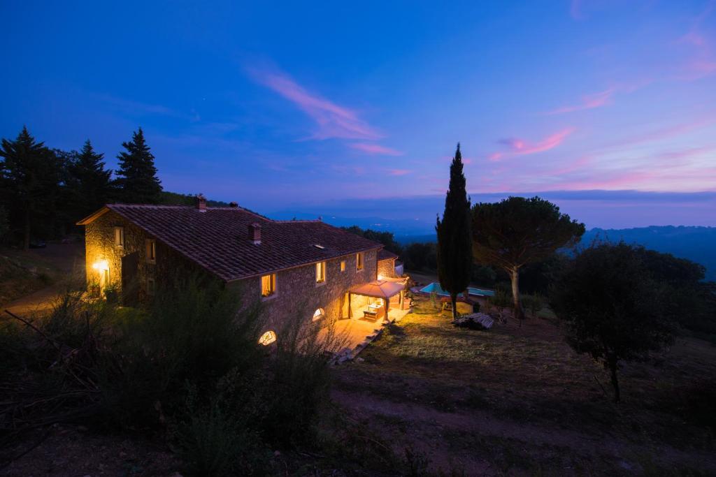 a small house with lights on it at night at B&B Podere Camaiano in Roccastrada