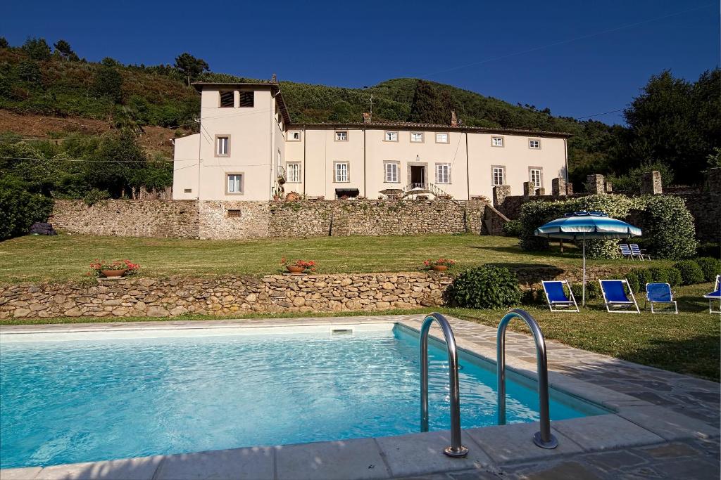 una casa grande con piscina frente a una casa en Villa Ilaria, en Capannori
