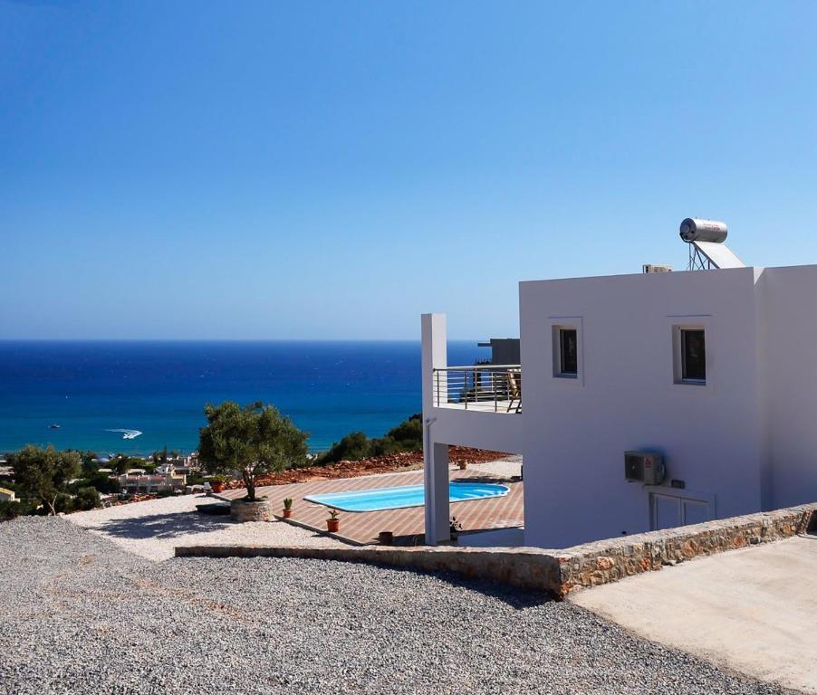 Casa blanca con piscina y océano en Villa Xenia Stalis en Stalida