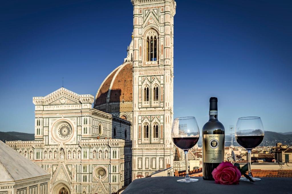 two glasses of wine sitting on a table in front of a building at B&B La Terrazza Sul Duomo in Florence