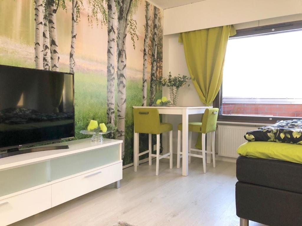 Il comprend un salon avec une télévision et une table à manger. dans l'établissement Maisa's studio Vieremä, à Vieremä