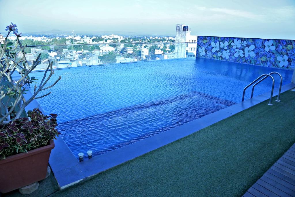 a swimming pool on the roof of a building at Hotel Vrishali Executive in Kolhapur